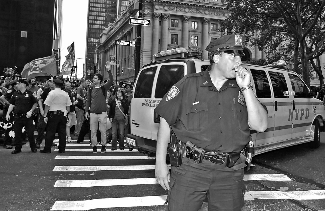 Occupy Wall Street NYPD Old School officer with protesters in backgroun